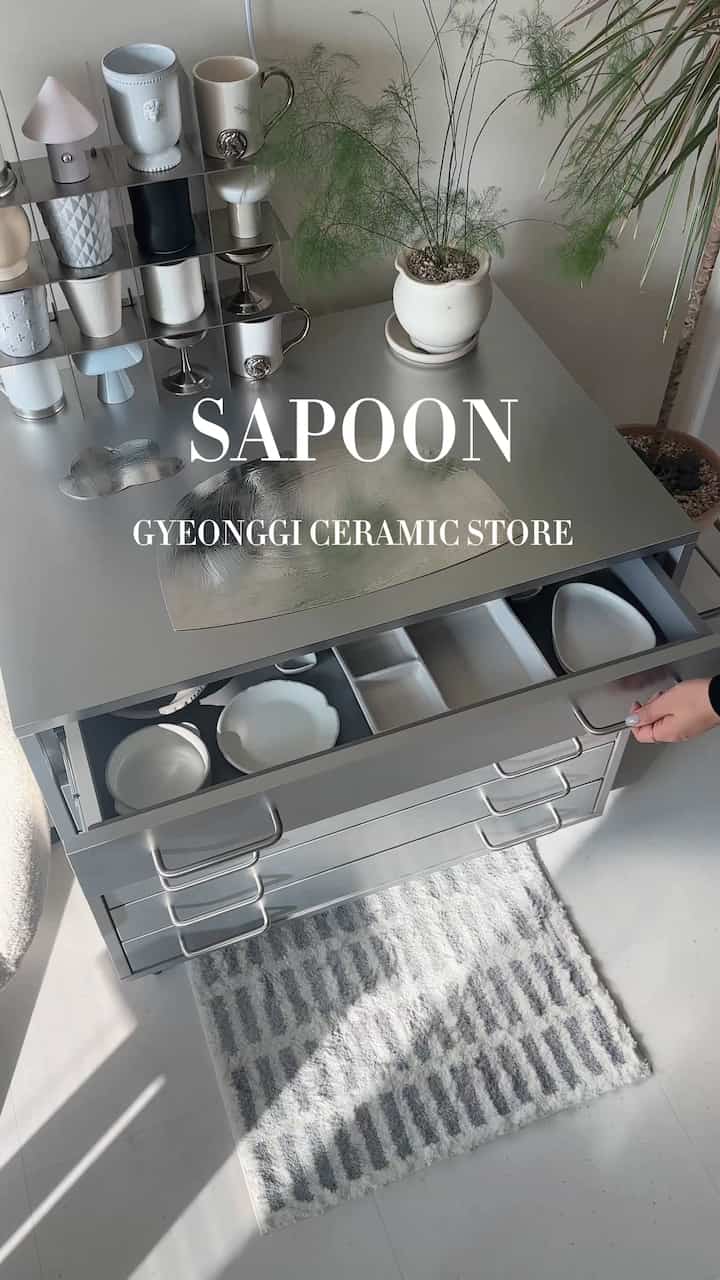 シルバーの金属製キャビネットに白い陶磁器が整然と並べられたモダンなおうちカフェインテリア