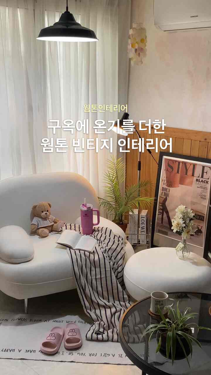 暖かみのある木製アートウォールと白いソファが配置された居心地の良いリビングインテリア