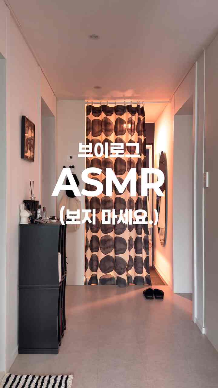 白黒のモノトーン玄関、大きな柄のカーテンと整った収納キャビネットが配された雰囲気のある空間