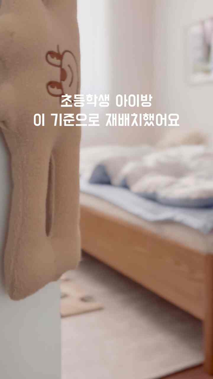 白い壁と木目調の家具が調和する子供部屋、勉強用デスクとベッドが効率的に配置されたミニマルな学習と休憩の空間