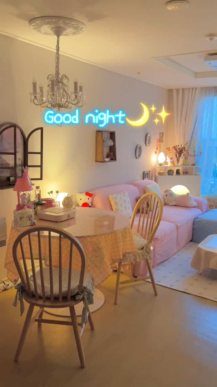 ピンクと黄色の暖かい光に包まれたリビング、ソファとダイニングテーブルが配置された雰囲気のあるインテリア